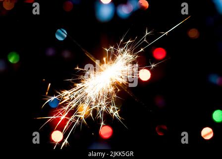 Burning  Bengal lights on Christmas tree light  background against defocused lights, close up Stock Photo
