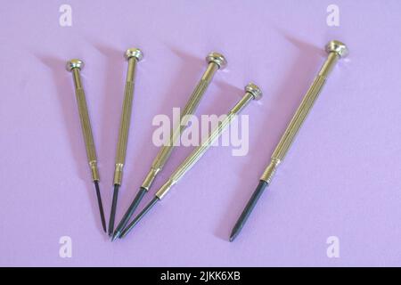 Different mini for delicate work on smallest screws in electronics and on purple background Stock Photo