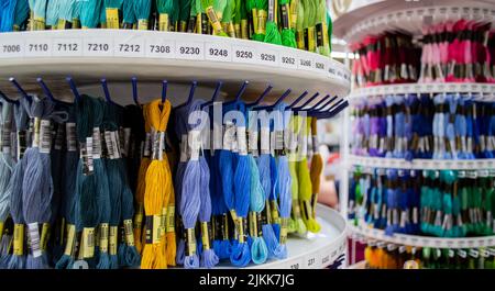 Moscow, Russia, August 2020: display Stand with multi-colored bright floss threads-sale in the shop of goods for needlework. Stock Photo