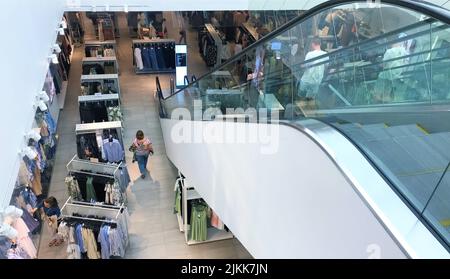 Moscow, Russia, June 2019: View from the second floor to the first inside the store HM clothes, buyers and escalator. Stock Photo