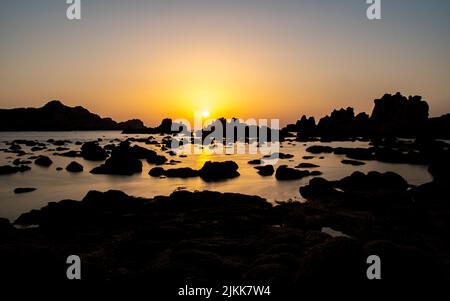 a panoramic shot of small rocky pond against of sunset Stock Photo