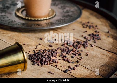 cacao nibs on whiskey barrel with drink in background Stock Photo