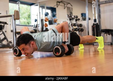 Athlete man in the gym doing weights Stock Photo