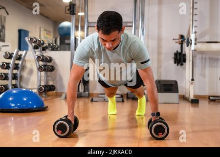 Portrait of a Caucasian man doing push-ups with weights with a lot of effort, healthy and healthy life doing sports Stock Photo