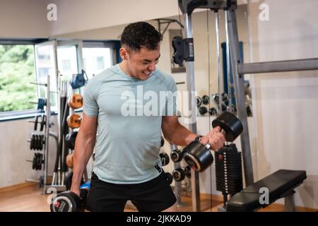 Athlete man in the gym doing weights Stock Photo