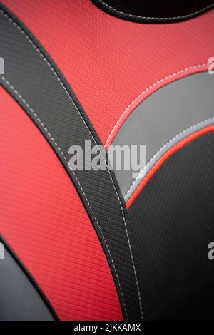Modern sport car with black and red leather interior. Part of leather car seat details with white stitching. Stock Photo