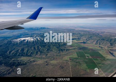 An aerial shot from an airplane flying over beautiful mountains Stock Photo