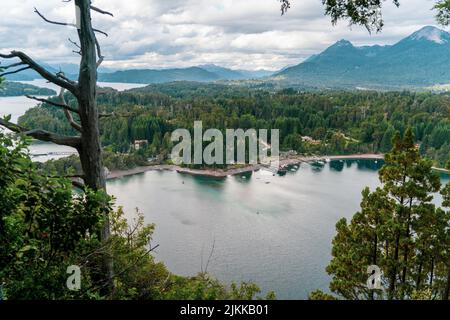 A beautiful aerial view of the river surrounded by dense forest and the mountains in the background Stock Photo