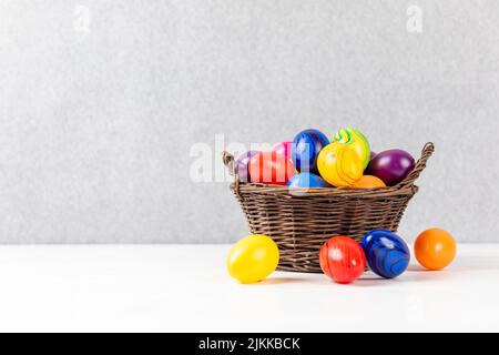 colorful easter eggs in a basket with gray background and copyspace Stock Photo