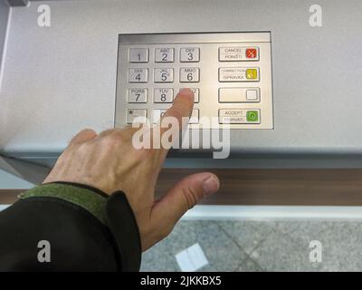 A close-up shot of a finger pressing buttons on an ATM machine. Stock Photo
