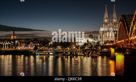 A scenic view of Hohenzollern Bridge in Cologne, Germany during Christmas time at night Stock Photo