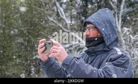 A closeup shot of a Caucasian man photographing the beautiful landscape Stock Photo