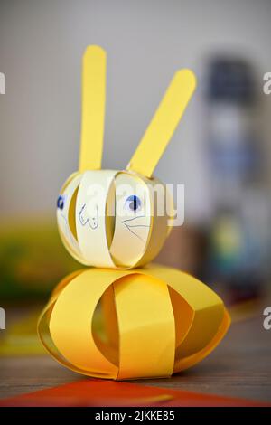 A closeup of a yellow origami rabbit on the table Stock Photo