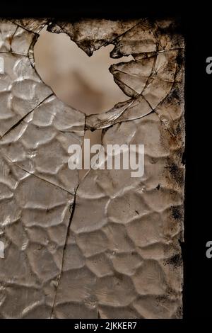 A closeup shot of a broken old dirty black window glass with blurred background Stock Photo