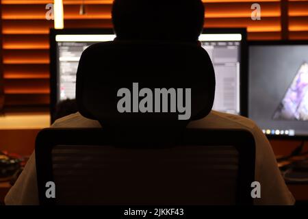 A man sitting in front of his desk full of computers Stock Photo