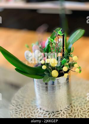 A vertical shot of an easter bouquet made with colorful eggs and green leaves Stock Photo
