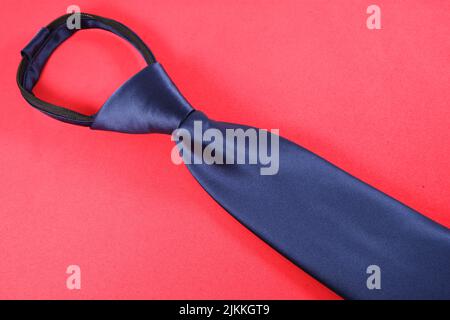 A blue necktie isolated on a red background Stock Photo