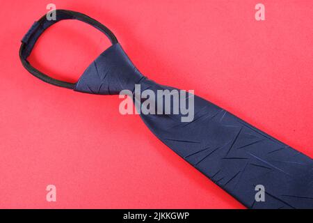 A blue necktie isolated on a red background Stock Photo