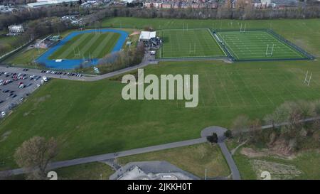 An aerial drone shot of a community sports stadium for rugby pitch and track and field in Warrington, England Stock Photo
