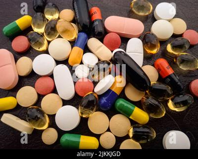 A closeup of medical pills and capsules isolated on a black background Stock Photo