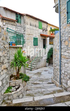 A vertical shot of stone houses with cute exterior in a narrow alley in Split, Croatia Stock Photo