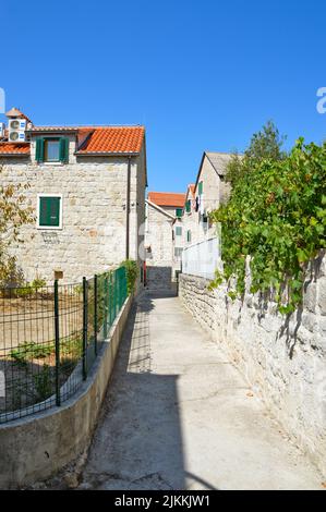 A vertical shot of a narrow alley with beautiful stone buildings in Split, Germany Stock Photo
