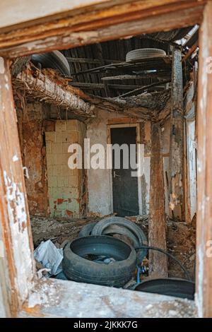 A closeup shot of an abandoned house with old tires Stock Photo