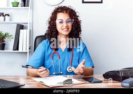 Latin american female doctor using a video chat in the clinic. Stock Photo