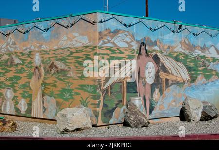 Mural of a Mojave traditional ways of a hunter with spear and shield in front of a dwelling and a woman carrying a water vessel on her head Stock Photo