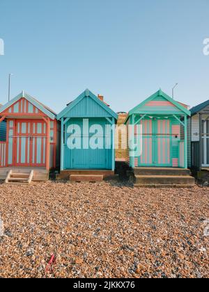 The colourful painted wooden beach huts on Herne Bay beach, North Kent coast England UK - summer summertime Stock Photo