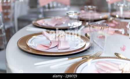 A beautiful wedding table setting, in pink and gold tones, the perfect combination of colors Stock Photo