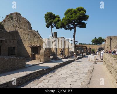 Tousists in a street in Herculaneum, a Roman city that was also covered by the Vesuvius eruption in 79 ad. It is smaller than Pompeii but was damaged Stock Photo