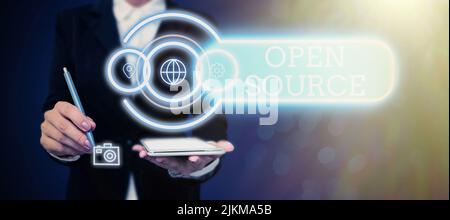 Text sign showing Open Source. Business overview denoting software which original source code freely available Businessman in suit holding tablet Stock Photo