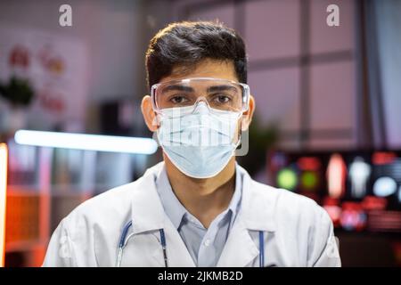 Portrait of professional indian man microbiologist or medical worker using protective mask in the laboratory. Stock Photo