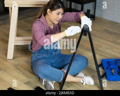The Asian handywoman apprentice working in a workshop Stock Photo