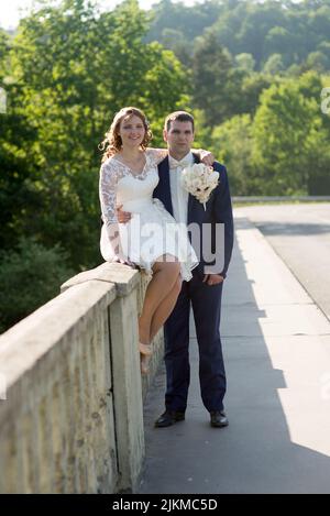 A vertical shot of a young married Caucasian couple posing in nature Stock Photo