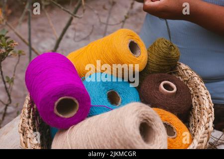 A closeup shot of the colorful sewing threads in the basket Stock Photo