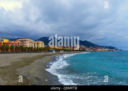 Ligurian sea, Italy: cityscape from the point of view of the beach with citizens walking in winter Stock Photo