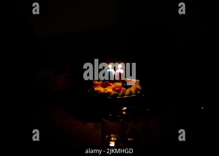 Candles in the shape of 8 and 9 are lit on the 89th Birthday Cake Stock Photo