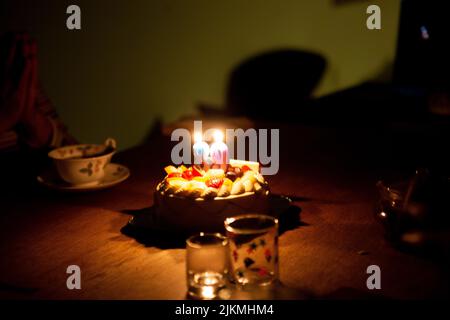 Candles in the shape of 8 and 9 are lit on the 89th Birthday Cake Stock Photo