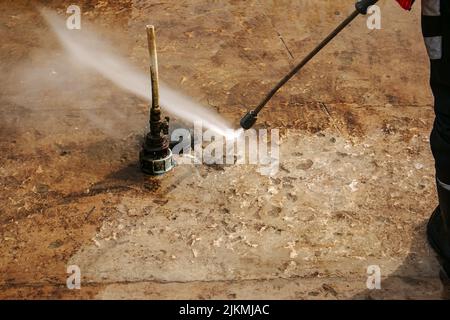 A man uses an electric pressure washer for a pressure washer. Cleaning city fountains in autumn. Workers remove the dirt that has settled during the s Stock Photo