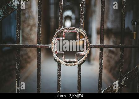 A rusty gate with a cross sign Stock Photo