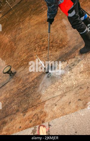 A man uses an electric pressure washer for a pressure washer. Cleaning city fountains in autumn. Workers remove the dirt that has settled during the s Stock Photo