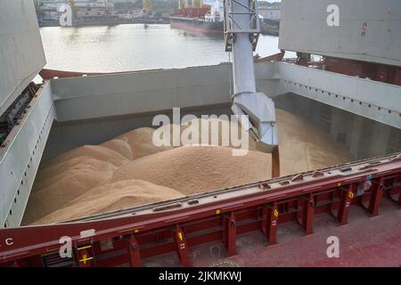 loading corn onto a bulk carrier ship in the port at the grain terminal. Port grain elevator. Industrial sea trading port bulk cargo zone grain termin Stock Photo