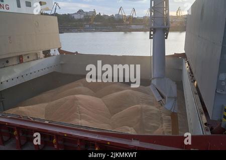 loading corn onto a bulk carrier ship in the port at the grain terminal. Port grain elevator. Industrial sea trading port bulk cargo zone grain termin Stock Photo