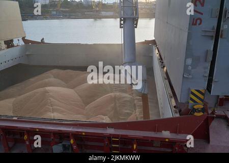 loading corn onto a bulk carrier ship in the port at the grain terminal. Port grain elevator. Industrial sea trading port bulk cargo zone grain termin Stock Photo