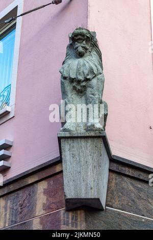 A vertical shot of a gargoyle on the facade of a building on a sunny day in downtown Dijon, France Stock Photo