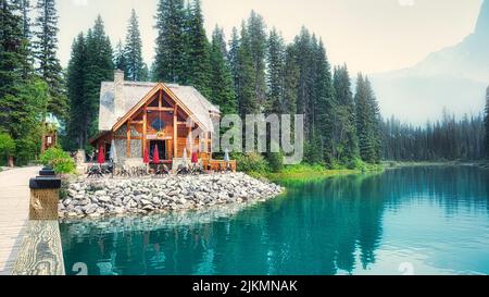 A view of a small country house with a terrace at a lake shore in a rural area in the forests Stock Photo