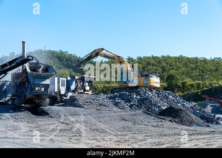 Mackay, Queensland, Australia - 7th June 2022: Machinery working in a quarry producing industrial rock and stone for construction of roads and other p Stock Photo