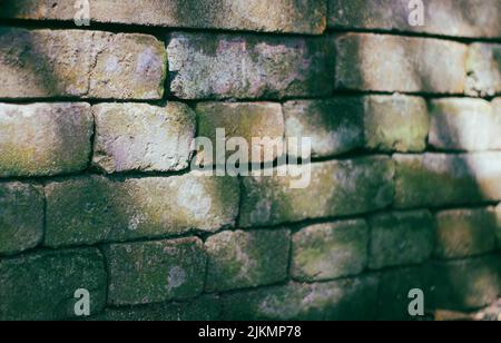A closeup of an old textured stone brick wall under sunlight Stock Photo
